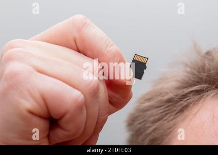 Holding micro SDHC card in a hand - shallow focus Stock Photo