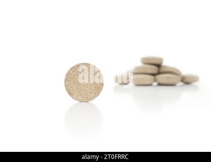 Round wafer tablet with defocused pile. Multiple green textured pressed tablets or pills. Isolated multivitamins for dogs, food supplement. Selective Stock Photo