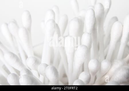 Pile of cotton swabs or q tip. Used to clean ears, remove make-up, cleaning and arts and crafts. Selective focus. Grey background. Stock Photo