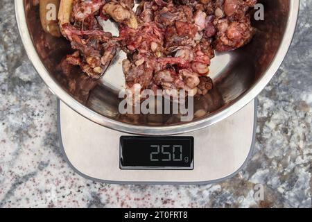 https://l450v.alamy.com/450v/2t0frt8/raw-ground-meat-on-food-scale-in-kitchen-top-view-measuring-portion-for-large-dog-on-raw-food-diet-or-barf-coarse-ground-beef-meat-with-muscle-bon-2t0frt8.jpg