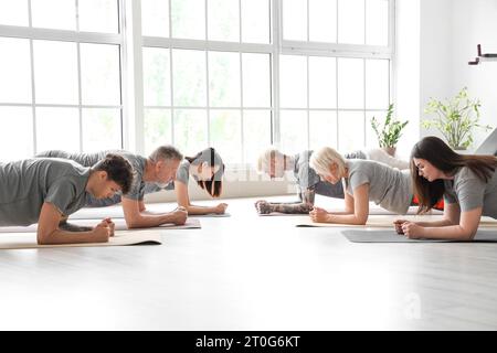 Group of sporty people doing plank in gym Stock Photo