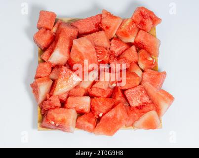Red and fresh peeled watermelon served on a wooden plate isolated on a white background Stock Photo