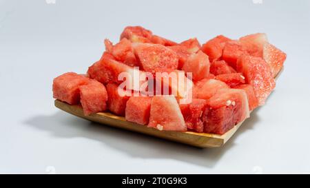 Red and fresh peeled watermelon served on a wooden plate isolated on a white background Stock Photo