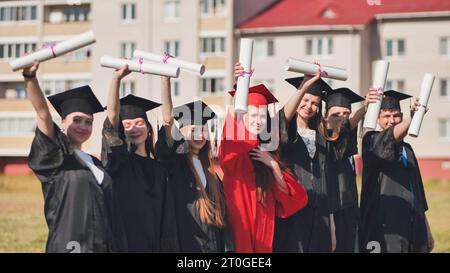 College graduates pose in the city wearing robes. Stock Photo