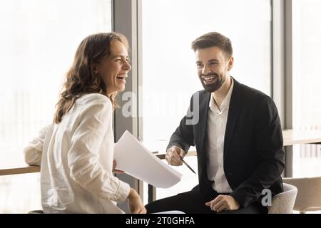 Cheerful young office friends brainstorming on project Stock Photo