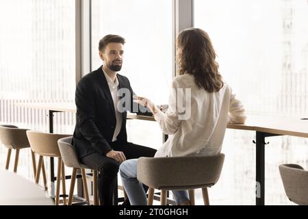 Focused couple of office friends talking in office lobby Stock Photo