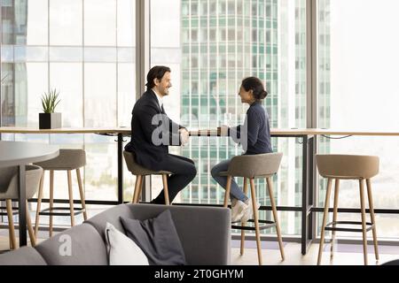 Positive Indian and Caucasian colleagues discussing cooperation Stock Photo