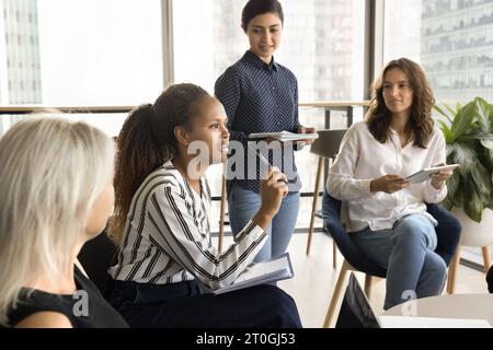 Pretty young African American employee speaking on corporate meeting Stock Photo
