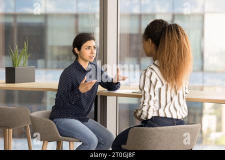 Serious young multiethnic project colleagues discussing collaboration Stock Photo