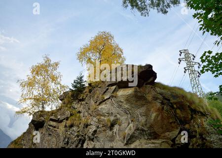 trees rock and high voltage pylon Stock Photo