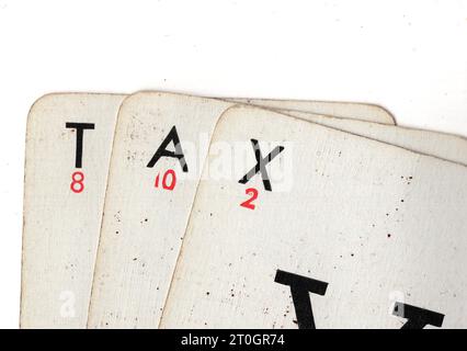 Vintage Lexicon playing cards spelling the word TAX on a white background. Stock Photo