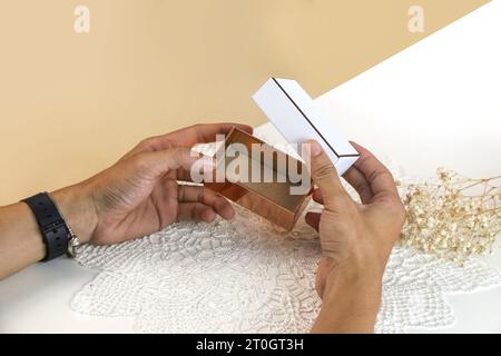 Male hands opening empty blank elegant luxury gift box. Mockup present gift box on light background stock photo Stock Photo