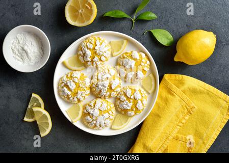 Lemon crinkle cookies on plate over dark stone background. Top view, flat lay Stock Photo
