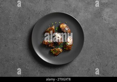 Roasted chicken liver on plate over dark stone background. Top view, flat lay Stock Photo