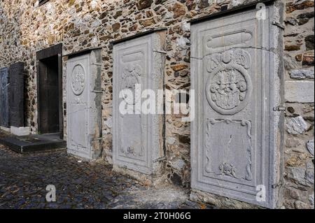 Huge grave slabs bearing coats of arms or armorial shields, fixed upright outside the medieval Cathedral of Saint George in Limburg-an-der-Lahn, Hesse, Germany. Stock Photo