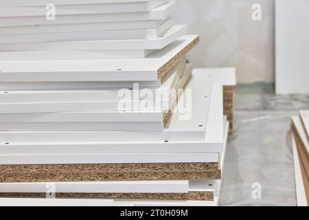 stack of white MDF panels lie on floor Stock Photo