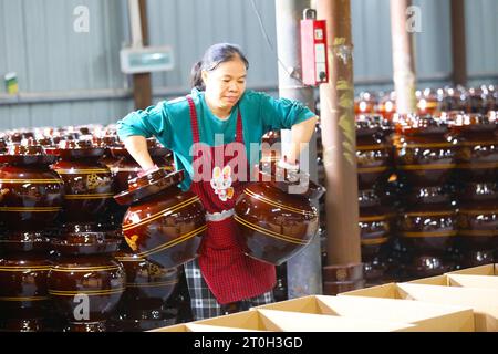 CHONGQING, CHINA - OCTOBER 7, 2023 - A worker boxes kimchi containers in a workshop in Chongqing, China, October 7, 2023. Stock Photo