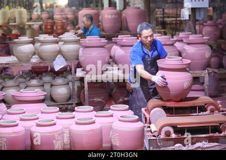 CHONGQING, CHINA - OCTOBER 7, 2023 - A worker glaze a wine tank in a workshop on October 7, 2023, Chongqing, China. Stock Photo