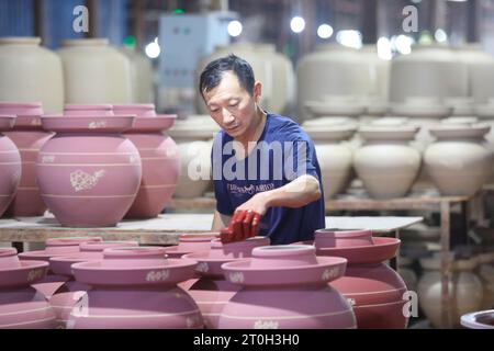 CHONGQING, CHINA - OCTOBER 7, 2023 - A worker glaze a wine tank in a workshop on October 7, 2023, Chongqing, China. Stock Photo