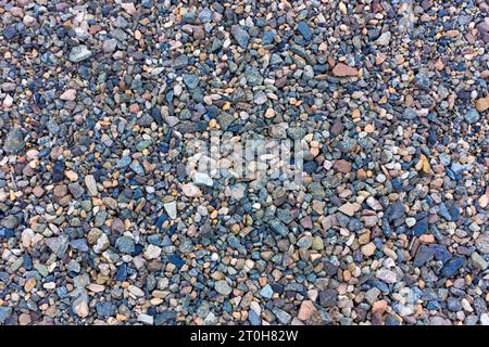 Stone background gravel. Granite texture. The rocky road. Fine pebbles. Construction material. The texture of the stones. Wallpaper with fine gravel. Stock Photo