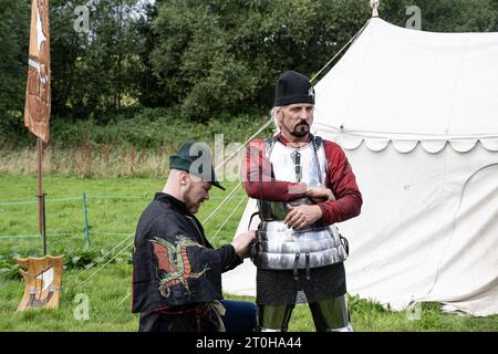 Kenilworth England  July 29th 2023 A knight  is  being  dressed by  his  squires  attaching his  armour Stock Photo