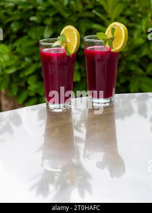 Freshly squeezed juice of beetroot with apple and lemon in a juice glass Stock Photo