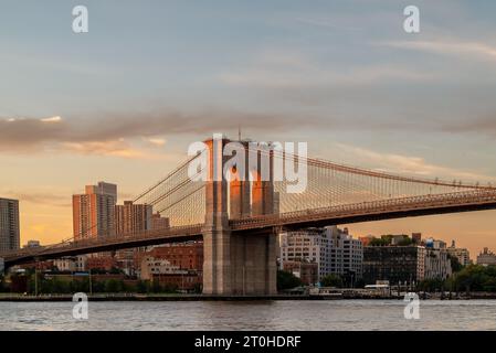 Amazing golden hour view about the Giant Brooklyn bridge over the East river in New York city. This bridge connects Manhattan and Brooklyn. Stock Photo