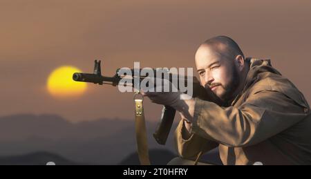 man shoots from a machine gun against the background of the desert Stock Photo
