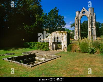 Twin healing wells, bathing pool, a reconstructed Norman doorway & the surviving E wall of Walsingham Abbey C14th church chancel, Norfolk, England, UK Stock Photo