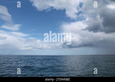 Blue Sky and White Clouds Over an Open Ocean Sea. Stock Photo