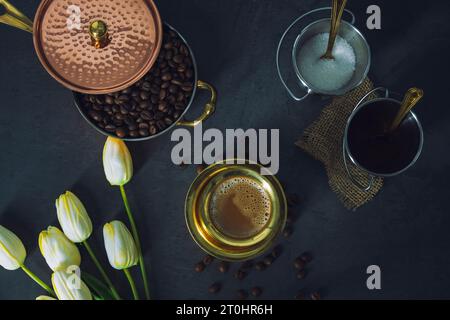 South Indian Filter coffee served in a traditional brass tumbler or cup with roasted raw coffee beans. Traditional Filter coffee served in a brass cup Stock Photo