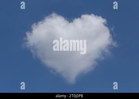 white fluffy valentine shaped cloud in a clear blue sky Stock Photo
