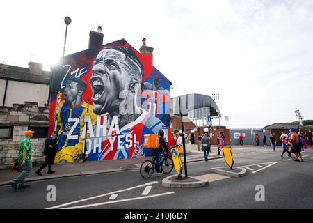 Fans walk past a mural of former Crystal Palace player Wilfried Zaha outside the stadium ahead the Premier League match at Selhurst Park, London. Picture date: Saturday October 7, 2023. Stock Photo