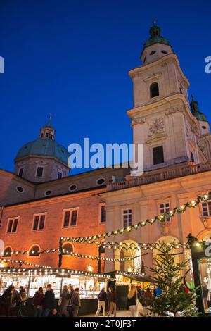 Christmas market on medieval Salzburg square before lockdown. Christmas tree and decoration in old town in Europe. Christmas fair in the evening. Stock Photo