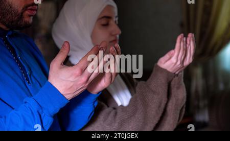 muslim couples praying together asking allah for mercy and forgiveness ,wearing casual clothes in home Stock Photo