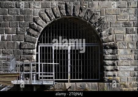 Entrance to scary stone tunnel under the water resevoir dam Bystricka in Czech republic. Creepy dark and wet place. Entry is forbidden. Stock Photo