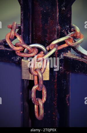 metal padlock with rusty chain that closes a large gate with toned old effect Stock Photo