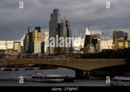 Waterloo Bridge over the river Thames with the skyscrapers of the City of London in the background at dusk. Photo taken from the Hungerford footbridge Stock Photo