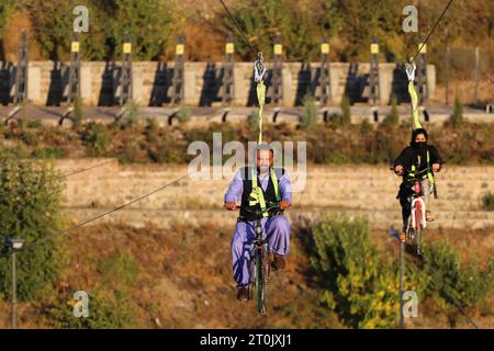 Hir, Ardabil, Iran. 5th Oct, 2023. Two Iranian rides a bicycle along a cable in the Heer recreation area near the city of Ardabil. Iran was elected as the tourism capital of the ECO countries in 2023. (Credit Image: © Rouzbeh Fouladi/ZUMA Press Wire) EDITORIAL USAGE ONLY! Not for Commercial USAGE! Stock Photo