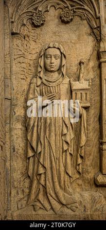 wooden relief of a nun in a long robe holding a church model, Ringsted, Denmark, October 2, 2023 Stock Photo