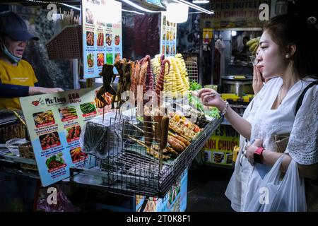 Hoi An, Vietnam. Night Market Street Food Vendor and Customers. Stock Photo