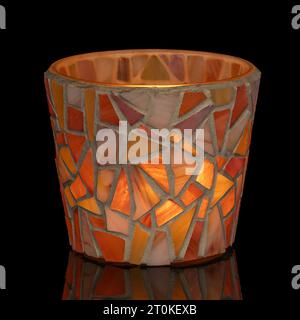 Candlelight glowing in the dark in colorful glass tiled mosaics holder. Stock Photo