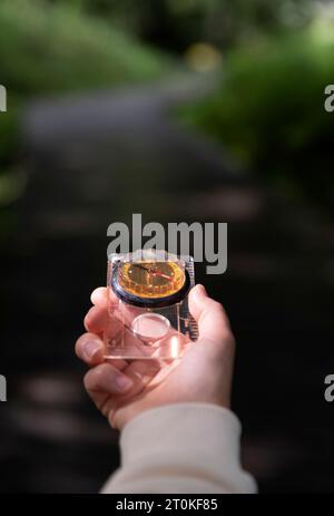 hand holding a compass in nature Stock Photo