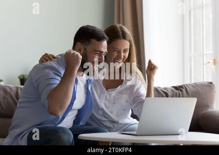 Excited overjoyed couple winning money prize, getting happy notice Stock Photo