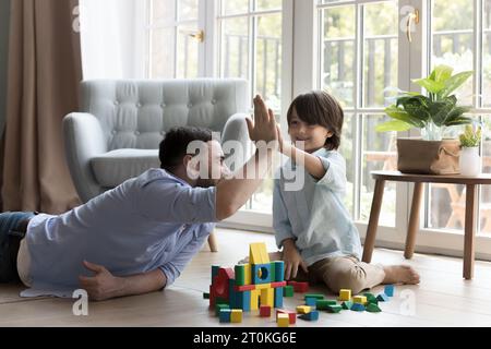 Happy father and little son boy playing constructing game Stock Photo