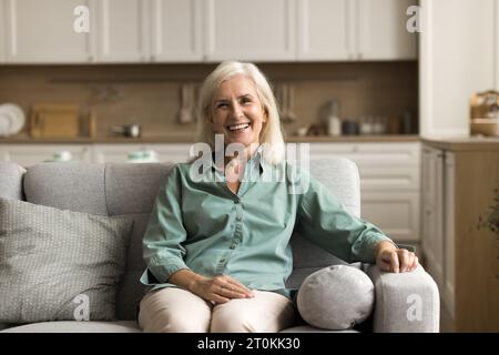 Positive blonde elderly woman relaxing at home Stock Photo