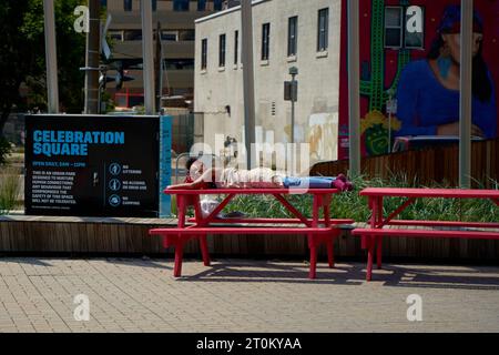 A homeless man sleeps on the street in Canada. Calgary, Canada - 06.29.23 Stock Photo