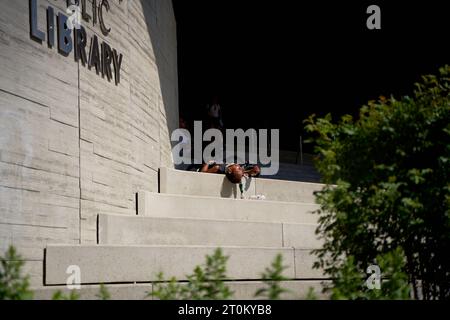 A homeless man sleeps on the street in Canada. Calgary, Canada - 06.29.23 Stock Photo