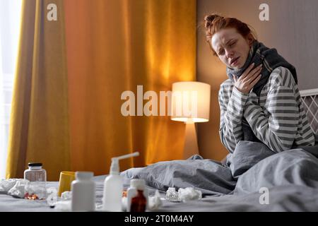 sad sick young Caucasian woman with sore throat at home health, cold and people concept closeup portrait, copy space Stock Photo