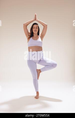 Caucasian pregnant woman practicing prenatal yoga in a studio. With her baby bump, she focuses on balance and meditation embracing a healthy lifestyle Stock Photo